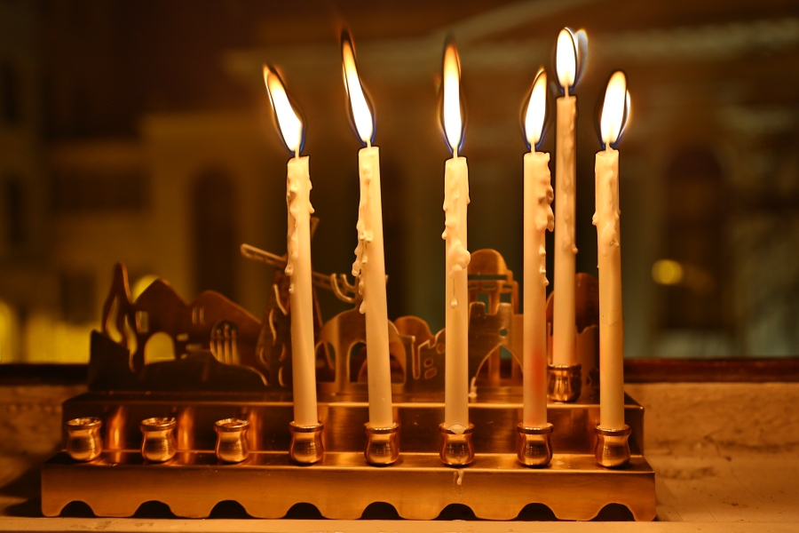 Pięć chanukowych świec w oknie naszej redakcji. W tle synagoga Pod Białym Bocianem.