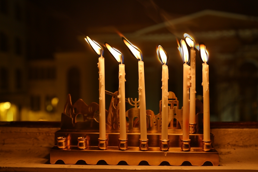 Sześć chanukowych świec w oknie naszej redakcji. W tle synagoga Pod Białym Bocianem.