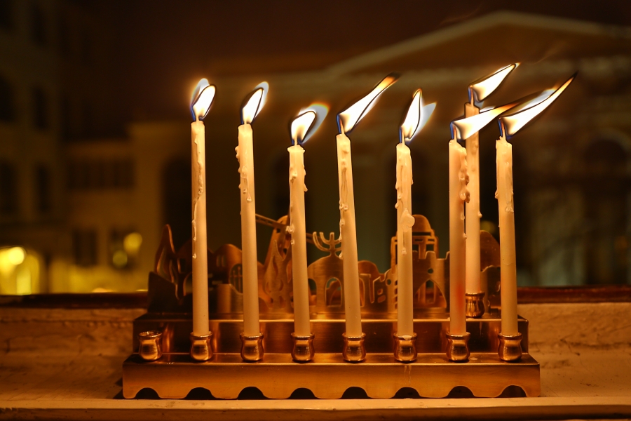 Siódma, przedostatnia świeca zapłonęła w oknie naszej redakcji. W tle synagoga Pod Białym Bocianem.